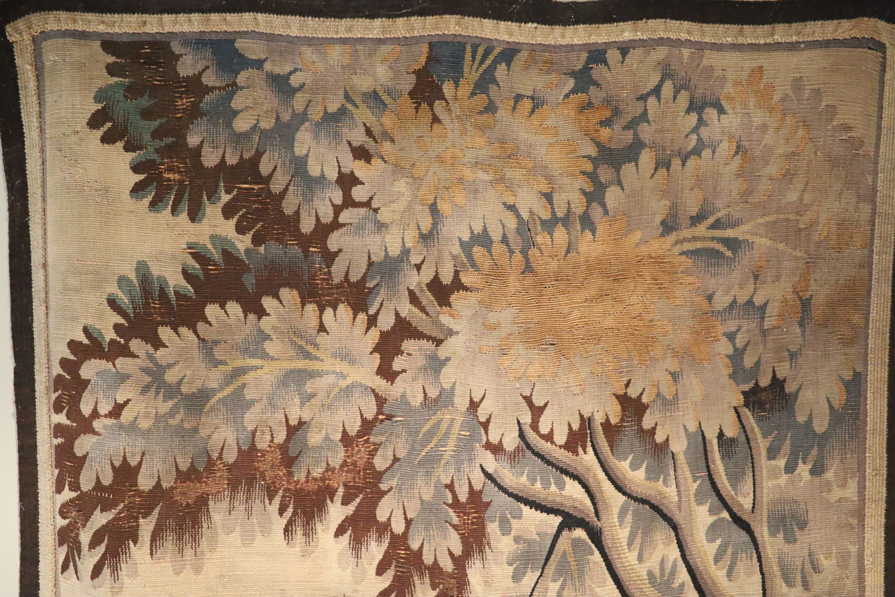 A French tapestry wall hanging, decorated with a town and trees, 125 x 79cm, with associated wrought iron hanging rail